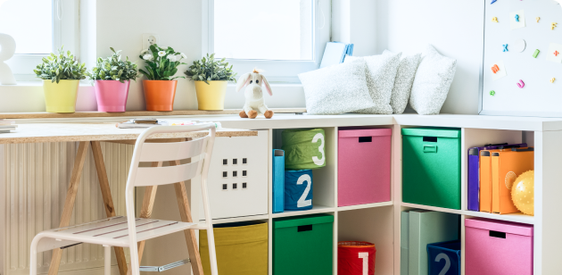 Kid-sized cubby with colorful bins and plants